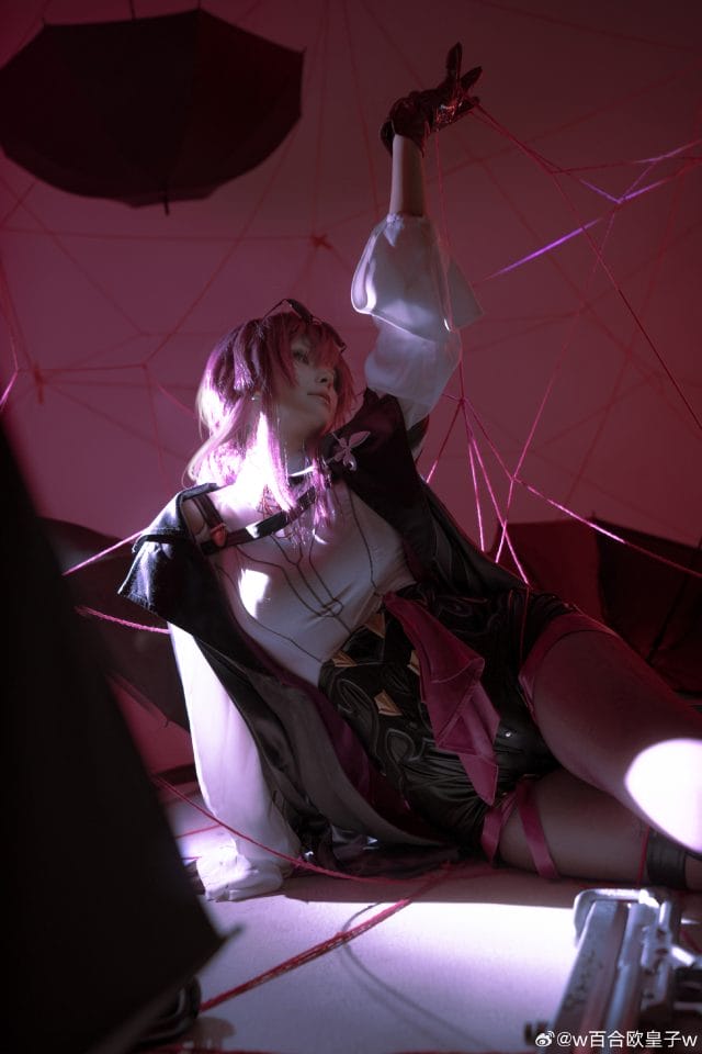 w百合欧皇子w COS星穹铁道卡芙卡写真:粉紫灯光下红瞳冷冽眼妆还原星核猎手的慵懒与锐利